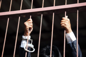 Corporate crime, businessman behind bars, criminal law