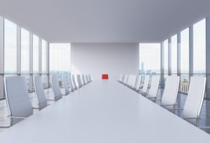 SIngle red chair in a white boardroom
