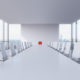 SIngle red chair in a white boardroom