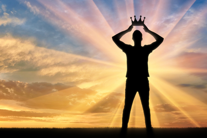 A narcissistic leader places a crown on his own head