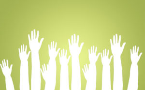 Group of raised hands on green background