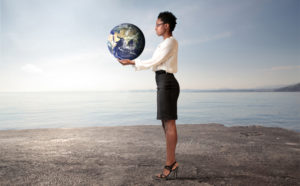 Businesswoman holding globe in arid landscape