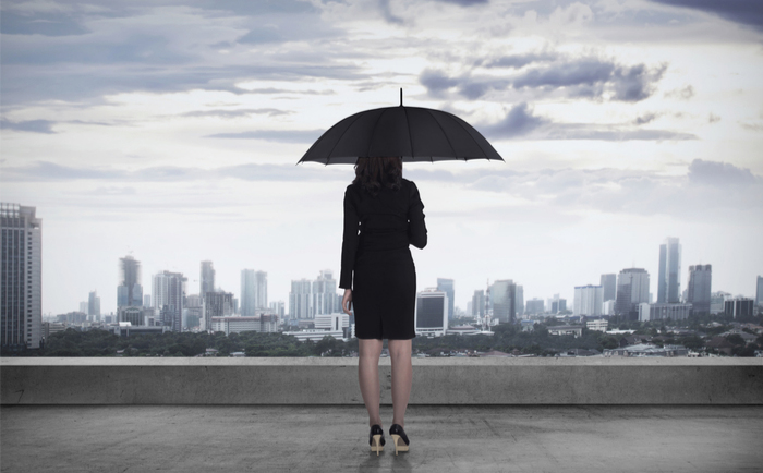 Businesswoman with umbrella overlooking the city